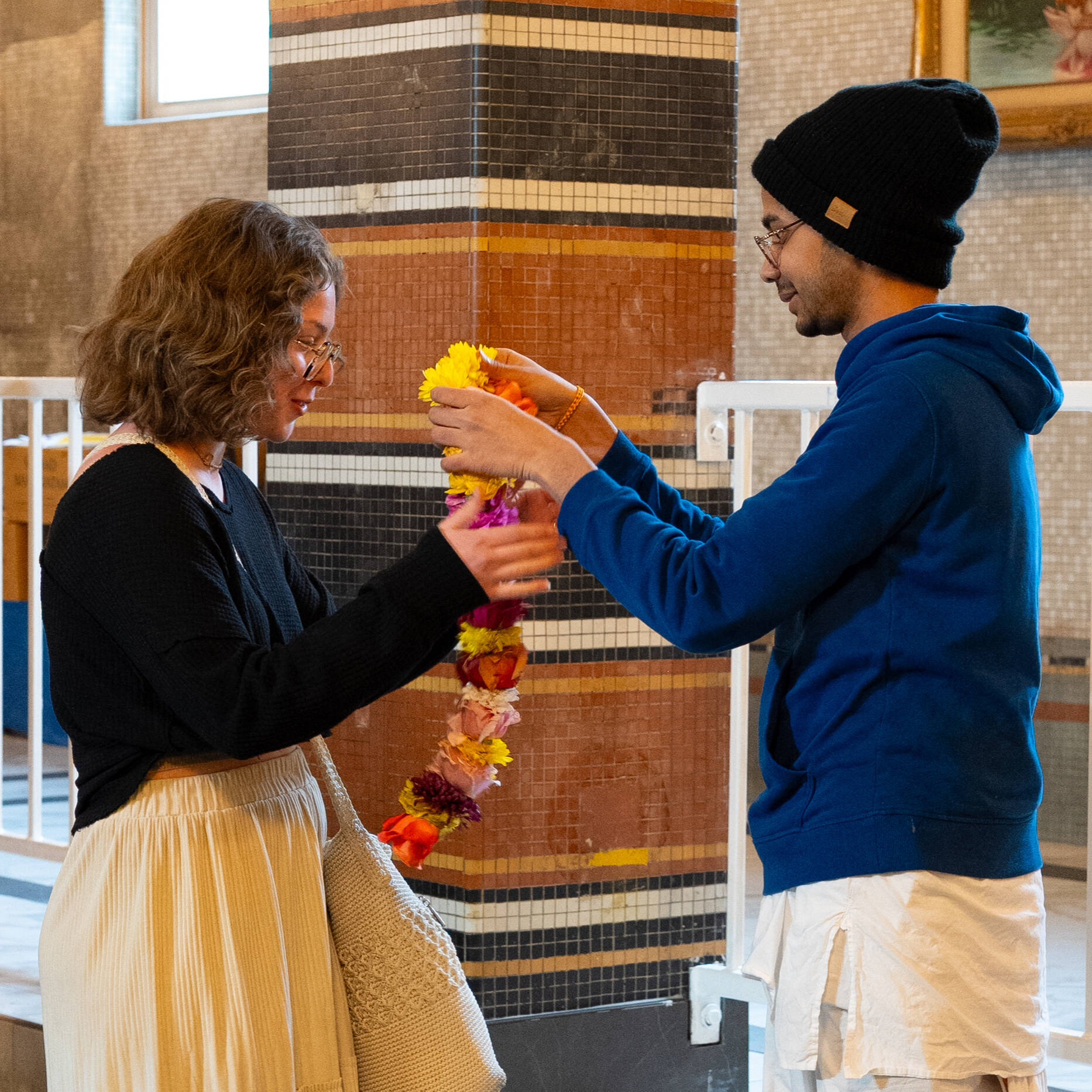 A student being gifted a large flower garland to wear.